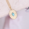 Collier ovale doré vintage avec texture rayon de soleil et pierre turquoise sur pierre - Bleu Lac