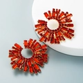 Macro-opname van gouden zonnebloem oorbellen met fonkelende rode kristallen strass - Rood