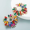 Detailed macro view of vibrant colorful rhinestone sunflower earrings on a geometric stand - Colorful