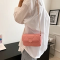 Moderna borsa a tracolla trapuntata rosa con catena dorata indossata da modella - Rosa
