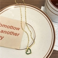 Collier cœur doré avec cristaux verts et chaîne fine sur une assiette minimaliste chic - Acier Inoxydable/Acier Titane/Zircone / Cœur en Strass Vert