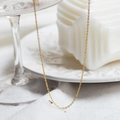 Elegant gold-plated stainless steel O-chain necklace displayed on a white ceramic tray - Gold Bead Chain