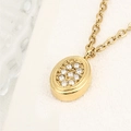 Elegante collana con ciondolo ovale dorato e zirconi scintillanti su supporto bianco - Forma Ovale (A4569)