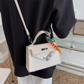 White embossed Kelly bag with cartoon patterns, floral scarf, and detachable strap - White