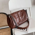 Borsa a tracolla vintage in pelle marrone con trapuntatura a quadri su una sedia - Marrone
