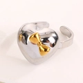 Dettaglio dell'anello a cuore regolabile con fiocco dorato 3D e finitura metallica lucida - Aperto Regolabile / Fiocco a Cuore (Oro Argento)