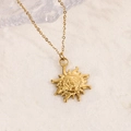 Detailopname van een 14K goud vergulde zonne-hanger ketting op een natuurstenen ondergrond - Zon