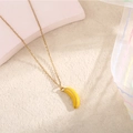 Dettaglio ravvicinato di una collana a catena dorata con pendente a forma di banana - Banana