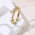 Detalle de anillo de cuentas doradas con mariposa y circonita blanca sobre base piedra - Rosa