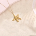 Close-up of a polished gold starfish pendant on a delicate stainless steel chain necklace - Mirror Starfish