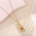 Detailed view of a gold-toned rock-on hand gesture pendant on a fine link chain necklace - Rock Gesture