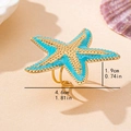 Teal enamel starfish ring with gold grainy texture on a beach-themed background - One Size / Blue