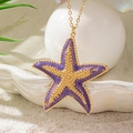 Collar bohemio con colgante de estrella de mar violeta y oro sobre fondo de arena - Púrpura