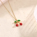 Collana dorata con delicato ciondolo a ciliegia in smalto rosso e verde vibrante - Piccola Ciliegia