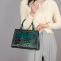 Deep green faux crocodile leather handbag with elegant buckle shown in a lifestyle pose - Green