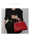Dettaglio borsa rossa con trama a coccodrillo e finiture dorate indossata da una modella - Borsa Singola / Rosso