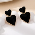 Detalle de pendientes de corazón negro con borde dorado en soporte ondulado - Negro