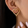 Minimalist twisted rope heart stud earrings in gold finish worn by a fashion model - Gold Yellow