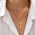 Collana con pendente a croce gotica dorata con motivi barocchi indossata su camicia bianca - Oro