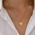 Collar minimalista con colgante de estrella de mar dorada martillada puesto en mujer - Amarillo Dorado