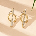 Dettaglio degli orecchini geometrici dorati con pavé di cristalli e design circolare - Giallo Oro