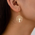 Goldene Lebensbaum-Ohrhänger getragen von einem Modell zeigen eleganten Vintage-Stil - Goldgelb