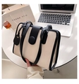 Elegante borsa tote bicolore panna e nera con dettagli a pieghe verticali sulla scrivania - Bianco