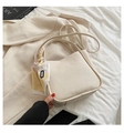 Minimalistische beige Beuteltasche mit Litschi-Textur und Seidenschal-Griff auf Stoff - Gebrochenes Weiß