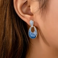 Fashionable gold-tone droplet earrings with blue marble enamel on a female model - Marble Pattern Waterdrop Style / Blue