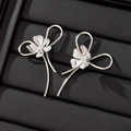 Orecchini a perno minimalisti a fiore in argento con linee curve su sfondo in pelle nera - Oro Bianco