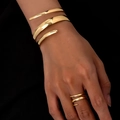 Set bracciale e anello a spirale dorati con finitura geometrica lucida su modella - Set di Bracciale e Anello Dorato
