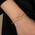 Minimalistischer goldener Armreif mit Herzdesign am Handgelenk für den Alltag - Goldgelb