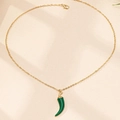 Detalle de un collar de cadena dorada con un colgante de chile en esmalte verde oscuro - Verde