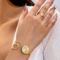 Elegante set di gioielli a spirale dorata con anello e bracciale rigido su modella - Spirale / Set di Bracciale e Anello Dorato