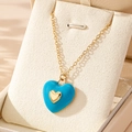 Light blue enamel heart pendant necklace with gold chain on jewelry display stand - Blue