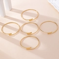 Detailed view of five stacked gold-plated minimalist bangles on a warm textured backdrop - Gold (5pcs Set)