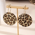 Detail of vintage leopard print hoop earrings with spiral texture on gold display - Leopard Print