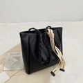 Minimalist black tote bag with woven handles and white lettered webbing strap details - Black