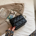 Schwarze Stepptasche mit goldener Kette und Kugelverschluss vor elegantem Hintergrund - Groß / Schwarz