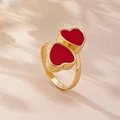 Detailaufnahme eines goldenen Rings mit zwei lebhaften roten Emaille-Herzen im süßen Stil - Rotes Doppelherz-Stil