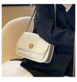 Elegant white quilted crossbody bag with gold rotating lock shown on model's shoulder - White