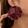 Deep red oversized floral stud earring featuring textured 3D pleated petals on model - Red