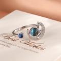 Nahaufnahme eines silbernen Rings mit blauem Galaxie-Stein und Pavé-Mond-Stern-Anhängern - Silberner Sternenhimmel Offener Ring (EP2350)