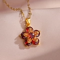 Makroaufnahme von rotierenden Blumenanhänger mit roten Steinen und Goldkette auf Satin - Roter Zirkonia