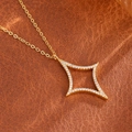 Elegante vergoldete Stern-Halskette mit Zirkonia auf Lederhintergrund präsentiert - Gold
