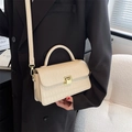 Chic beige crocodile pattern crossbody bag worn with a black suit for professional style - Off White