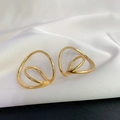 Detail of gold Mobius ear clips with double-layered geometric wire design on white silk - Gold