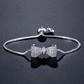 Adjustable silver bow bracelet featuring sparkling zircon stones and slide bead closure - Silver