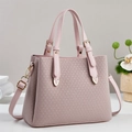 Dettaglio borsa tote rosa intrecciata con hardware dorato e tracolla rimovibile - Rosa