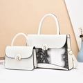Detail of white leather tote set with snake skin pattern and metal circular lock clasp - White